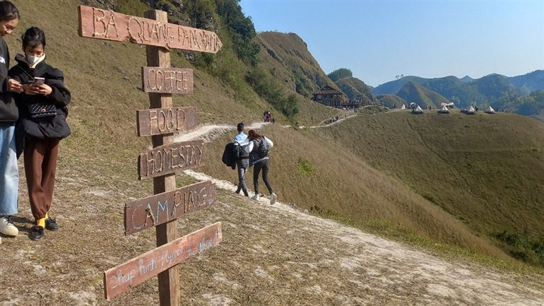 Biển chỉ dẫn vào khu camping đồi cỏ Ba Quáng, với khu nhà sàn và những lều vải xinh xắn, thơ mộng.