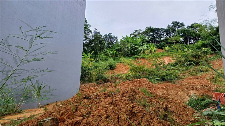 Đất đá tràn lấp vào cạnh nhà, sau nhà ông Lý Đặng Thắng ở Khu tái định cư Sông Hiến.