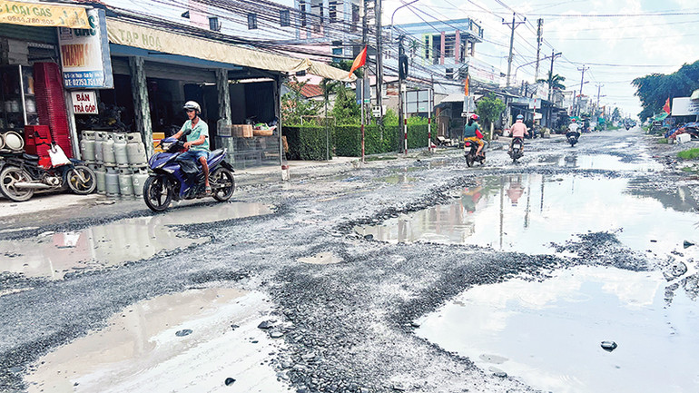 Tuyến Quốc lộ 57B qua xã Lộc Thuận (huyện Bình Đại) bị hư hỏng nặng, đọng nước làm nhiều phương tiện qua lại rất khó khăn.