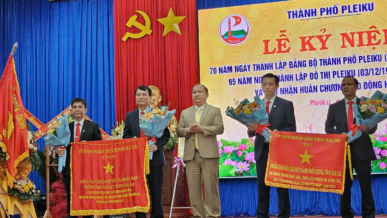 Đồng chí Ra Land Chung, Chủ tịch UBND tỉnh trao cờ vì sự nghiệp xây dựng tỉnh Gia Lai cho Đảng bộ, chính quyền và nhân dân thành phố Pleiku.