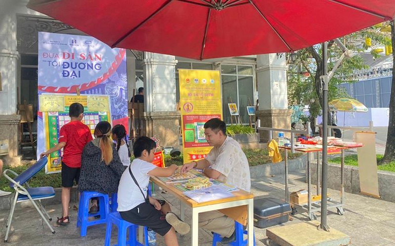 Ông Bùi Chính Hưng chơi cờ chữ Việt với một bạn nhỏ.