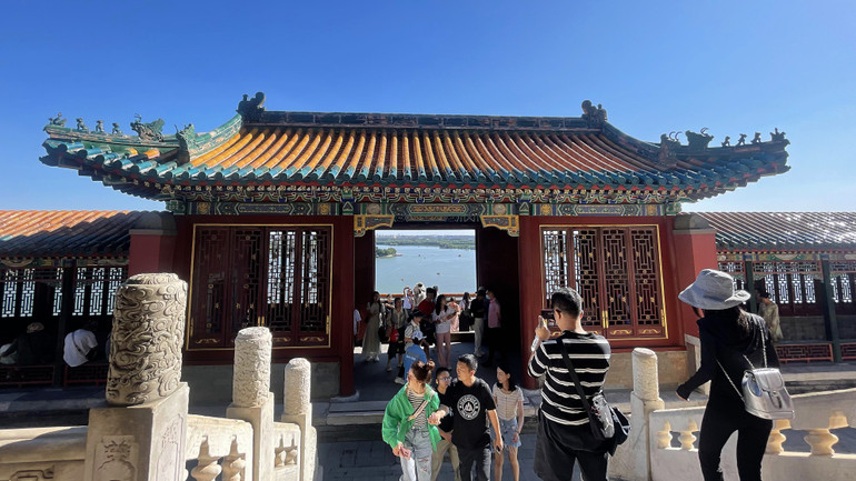 Du khách lưu lại hình ảnh Di Hòa viên thu nhỏ qua cổng Phật Hương các. (Ảnh: HỮU HƯNG)