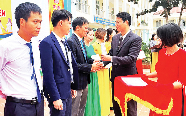 Trao giấy chứng nhận cho các giáo viên đạt danh hiệu giáo viên dạy giỏi cấp huyện. (Ảnh THU TRANG)