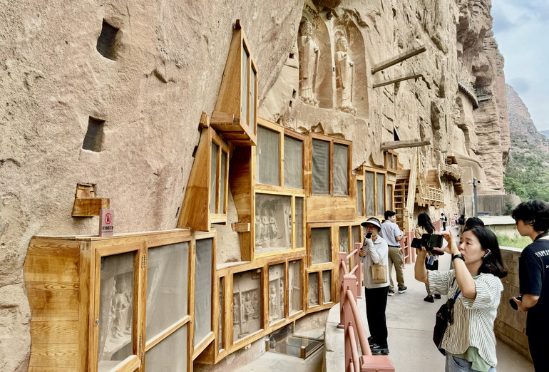 Du khách thích thú ngắm nhìn những bức tượng nghìn năm tuổi.