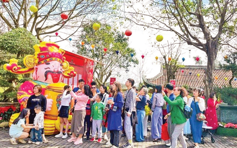 Du khách hào hứng xếp hàng xin vía Thần Tài đầu năm và tham gia lễ diễu hành. (Ảnh THANH TÙNG)