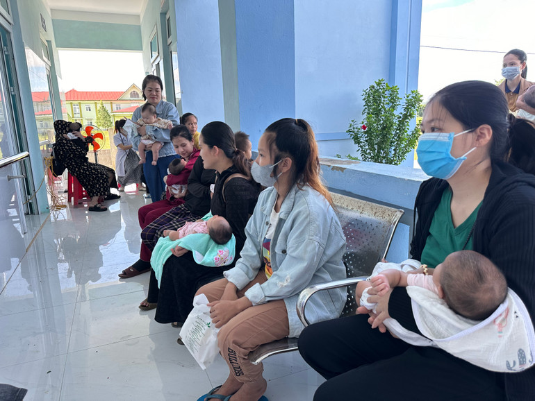 Bà mẹ và trẻ em ngồi chờ tiêm vaccine tại Trạm y tế xã Cam Tuyền.