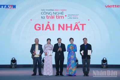 Tổng Giám đốc TTXVN Vũ Việt Trang, Chủ tịch Hội đồng Giải thưởng và Thứ trưởng Bộ Văn hóa, Thể thao và Du lịch Tạ Quang Đông trao giải Nhất cho các tác giả. (Ảnh: THANH GIANG)