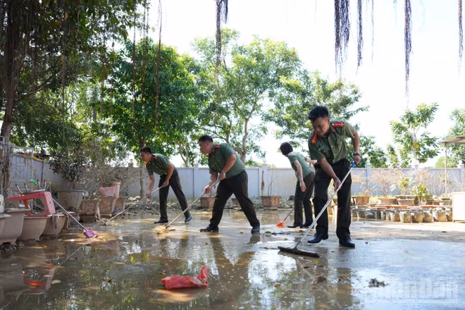 Đại úy Nguyễn Văn Kiên (ngoài cùng bên phải) cùng đồng đội hỗ trợ khắc phục hậu quả bão lũ tại chùa An Lạc.