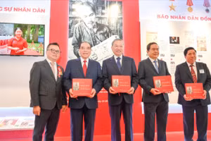 Tổng Bí thư Tô Lâm, các đồng chí lãnh đạo Đảng, Nhà nước và các đại biểu nhận cuốn sách " Những bài viết về văn hóa, báo chí của Bác Hồ trên Báo Nhân Dân" tại gian trưng bày của Báo Nhân Dân. 