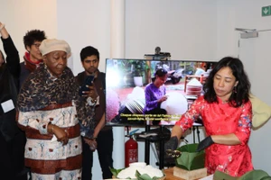 Chị Nguyễn Thị Liên, Việt kiều tại Brussels, giới thiệu cách gói bánh chưng. (Ảnh: HƯƠNG GIANG/TTXVN)