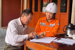 Cán bộ Điện lực Hương Sơn hướng dẫn khách hàng ký cam kết tiết kiệm điện.
