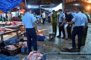 Lực lượng chức năng kiểm tra ki-ốt kinh doanh thịt lợn "bẩn" tại khu vực chợ Phùng Khoang. (Ảnh: Công an thành phố Hà Nội cung cấp)