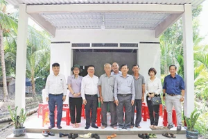 Lãnh đạo Báo Nhân Dân chụp ảnh lưu niệm trong một lần tặng quà hỗ trợ xây dựng nhà “Đại đoàn kết” khu vực Đồng bằng sông Cửu Long. Ảnh: BÁ DŨNG