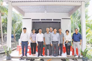 Lãnh đạo Báo Nhân Dân chụp ảnh lưu niệm trong một lần tặng quà hỗ trợ xây dựng nhà “Đại đoàn kết” khu vực Đồng bằng sông Cửu Long. Ảnh: BÁ DŨNG