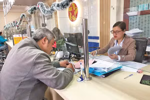 Cán bộ Trung tâm phục vụ hành chính công phường Lang Biang - Đà Lạt làm thủ tục hành chính phục vụ người dân.