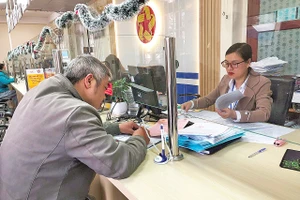 Cán bộ Trung tâm phục vụ hành chính công phường Lang Biang - Đà Lạt làm thủ tục hành chính phục vụ người dân.