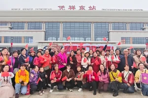 Hành khách chụp ảnh trước ga Bằng Tường Đông. (Ảnh: Nhân dân nhật báo)