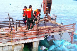 Cán bộ, chiến sĩ Đồn Biên phòng Hòn Chuối hỗ trợ trục vớt tàu cá gặp nạn trên vùng biển Cà Mau. 