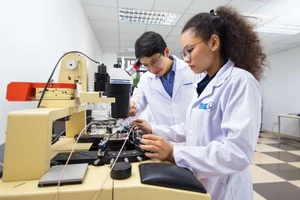 Tiến sĩ Nguyễn Viết Hương (bên trái) thực hành thí nghiệm. (Ảnh NVCC)