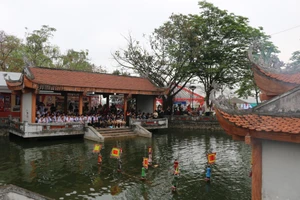 Ao làng rộn rã tiếng cười khi các em học sinh xem biểu diễn rối nước.