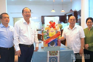 Bí thư Tỉnh ủy Nguyễn Hồ Hải (thứ hai, từ trái qua) trao tặng quà cho gia đình đồng chí Phạm Thanh Trị.