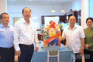 Bí thư Tỉnh ủy Nguyễn Hồ Hải (thứ hai, từ trái qua) trao tặng quà cho gia đình đồng chí Phạm Thanh Trị.
