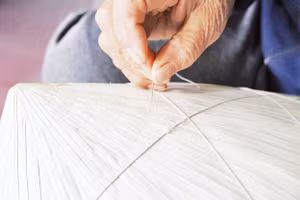 Người dân làng Sai Nga tỉ mỉ hướng dẫn du khách tập khâu nón.