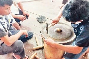 Các học viên thực hành chỉnh âm cồng chiêng tại lớp tập huấn do nhà nghiên cứu Bùi Trọng Hiền hướng dẫn. 
