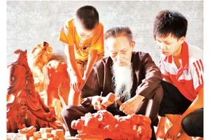Nghệ nhân làng nghề gỗ mỹ nghệ Thiết Úng truyền nghề cho con, cháu. Ảnh: Đỗ Phong 