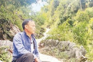 Bí thư Chi bộ Thào A Quả bên một đoạn đường anh đã vận động bà con chung sức hoàn thành. Ảnh: Doãn Hoàng 