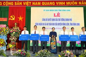 Lãnh đạo tỉnh Vĩnh Long trao thẻ bảo hiểm y tế cho các xã được công nhận An toàn khu. (Ảnh tư liệu)