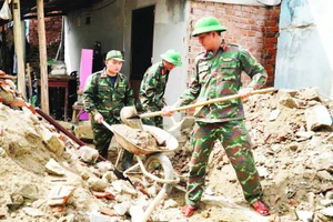 Cán bộ, chiến sĩ Trường Quân sự (Quân đoàn 34, tỉnh Gia Lai) hỗ trợ sửa chữa, xây dựng nhà cửa cho người dân sau bão lũ tại phường Ngô Mây.