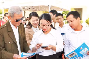 Cán bộ phường An Phong hướng dẫn người dân lấy số thứ tự giải quyết thủ tục hành chính trên VNeID.