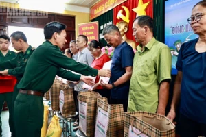 Thượng tá Nguyễn Văn Lập, Chủ nhiệm chính trị Bộ đội Biên phòng thành phố Hải Phòng trao quà và tặng cờ Tổ quốc cho các hộ dân trên đảo.