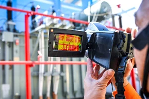 Công nhân EVNHANOI sử dụng máy đo nhiệt kiểm tra tình trạng thiết bị điện tại trạm biến áp vận hành không người trực. Ảnh: Thành Đạt 