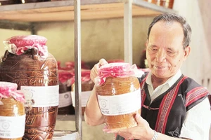 Ông Lê Văn Nghĩa kiểm tra chất lượng sản phẩm rượu cần. 