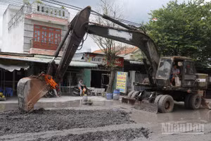 Đơn vị thi công dùng xe múc sửa chữa nền đường Bưng Môn.