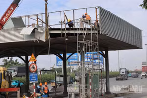 Đơn vị thi công tiến hành tháo dỡ trạm thu phí ngưng hoạt động ở khu vực cầu Đồng Nai trong ngày 11/8. (Ảnh: THIÊN VƯƠNG)