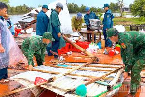Cán bộ, chiến sĩ Đồn biên phòng Khánh Tiến chung tay cùng địa phương giúp người dân khắc phục hậu quả sau thiên tai.