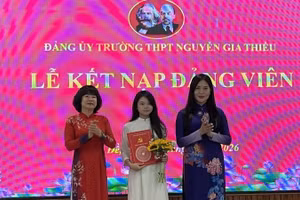 Bí thư Đảng ủy, Chủ tịch Hội đồng nhân dân phường Bồ Đề Vũ Thị Thành (người đứng bên trái) trao quyết định kết nạp Đảng cho học sinh trường Trung học phổ thông Nguyễn Gia Thiều.
