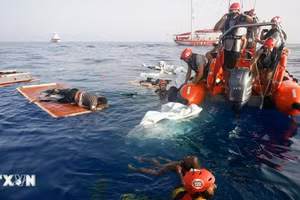 Tàu của Lực lượng bảo vệ bờ biển Italia vớt thi thể người di cư trôi dạt trên Địa Trung Hải. (Ảnh: AFP/TTXVN)