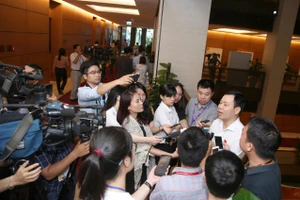 Phóng viên phỏng vấn đại biểu Quốc hội bên hành lang kỳ họp. (Ảnh: DUY LINH)