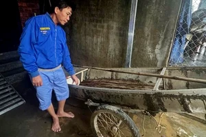 Ông Trần Công Thành bên chiếc ghe nhỏ dùng để cứu người trong lũ dữ.