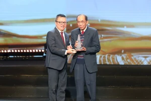 Đồng chí Lê Quốc Minh, Ủy viên Trung ương Đảng, Tổng Biên tập Báo Nhân Dân, Phó Trưởng ban Tuyên giáo và Dân vận Trung ương, Chủ tịch Hội Nhà báo Việt Nam, trao giải Phụng sự thầm lặng tới bác sĩ Lê Thành Đô. (Ảnh Minh Lê)