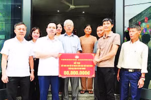 Bí thư Đảng ủy xã Phú Nghĩa Trịnh Tiến Tường (bên trái) trao biển hỗ trợ nhà ở cho hộ có hoàn cảnh khó khăn trên địa bàn.