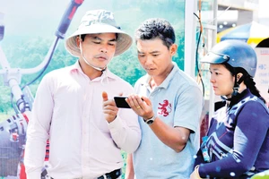 Người nông dân tìm hiểu các ứng dụng của điện thoại thông minh để phục vụ cho sản xuất. Ảnh: Hải Nam