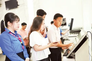 Sinh viên Học viện Cán bộ Thành phố Hồ Chí Minh hướng dẫn người dân thực hiện thủ tục hành chính tại Ủy ban nhân dân phường Sài Gòn.