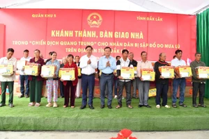 Các đồng chí lãnh đạo tỉnh Đắk Lắk bàn giao nhà trong "Chiến dịch Quang Trung" và tặng quà cho người dân vùng lũ.