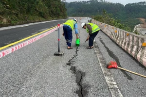 Công nhân giao thông tiến hành nhồi dây đay, tưới nhựa để bịt vết nứt nhằm ngăn nước thấm xuống phía dưới đường.