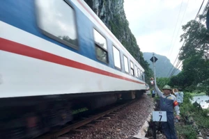 Nhân viên tuần hầm hướng dẫn tàu qua an toàn trên đoạn đường sắt xung yếu bên sông, bên núi đá ở huyện Tuyên Hóa, tỉnh Quảng Bình.